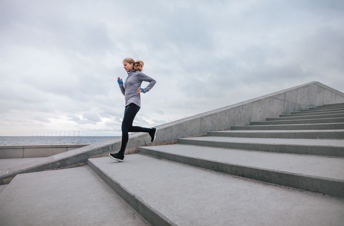 Healthy sports woman running down the stairs