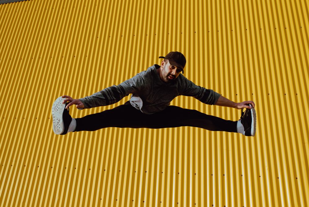 Man jumping near yellow wall