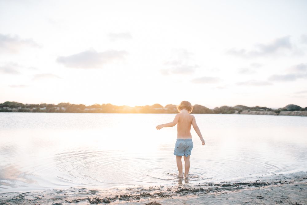 Boy walking in water of lake