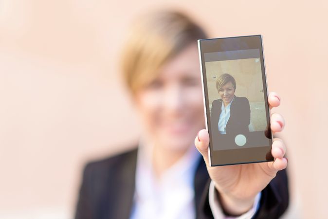 Woman showing picture on her phone screen with selective focus