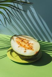 Half Melon toad skin, Colorful summer theme. in blue and green background, shadows of palm leaves