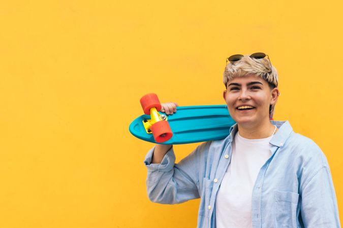 young woman with a skate and short hair laughing. portrait