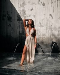Woman standing in dress in fountain pool