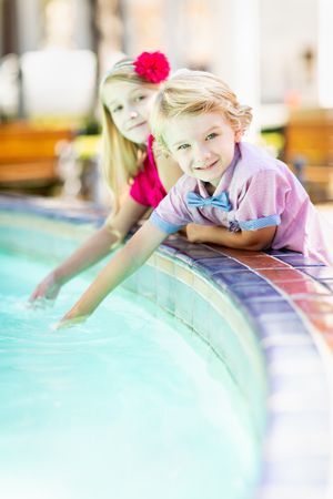 Cute Young Brother and Sister Enjoying The Fountain At The Park