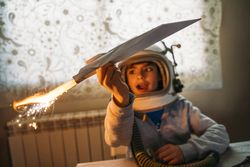 Dreamy kid having fun with toy airplane