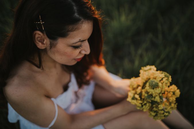 Barefoot woman with flowers in meadow