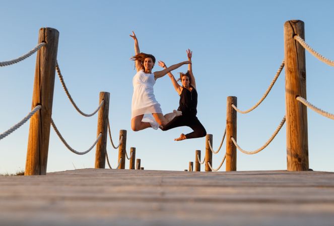 Women posing in air on footbridge