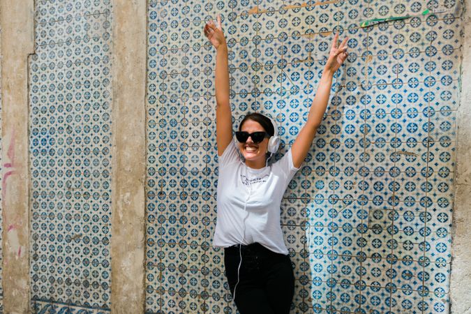 Cheerful casual woman in sunglasses standing on city street