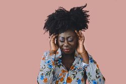 Portrait of Black woman with a pensive expression and both hands to her head