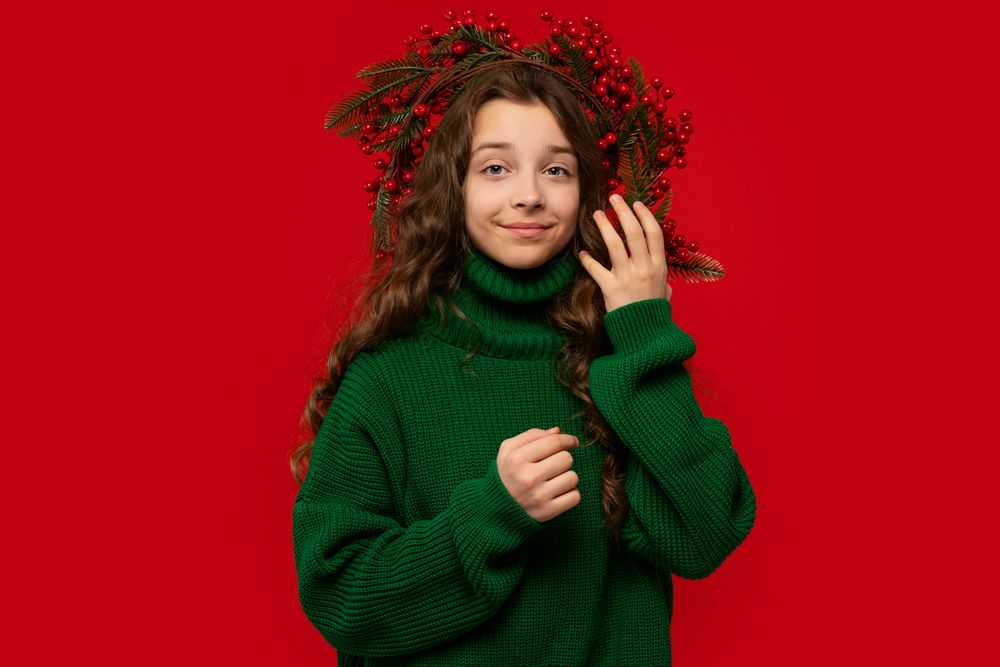 Teen girl wearing green sweater and Christmas berry wreath