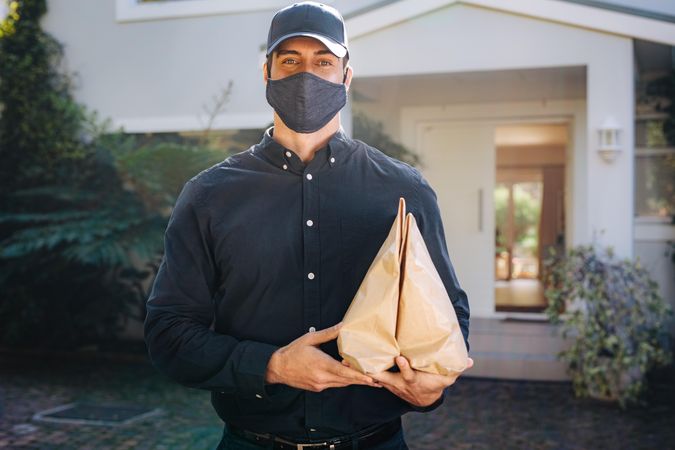 Delivery person with parcels to be delivered on home addresses during Covid-19