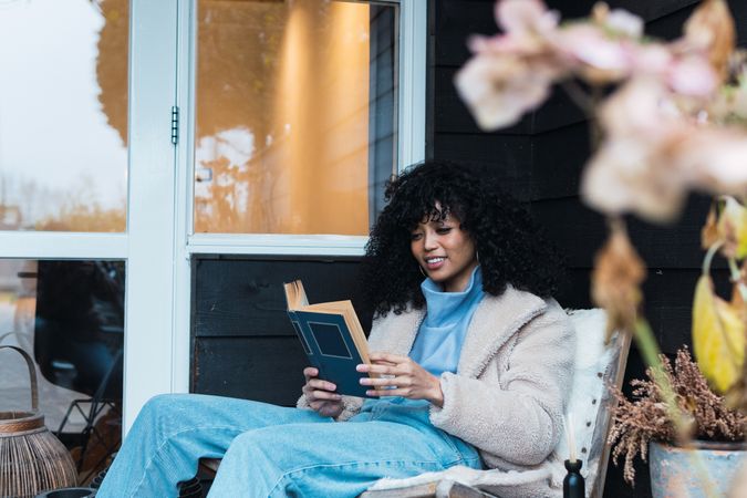 Black woman reading book outside