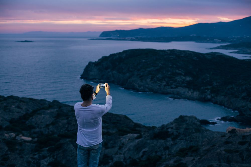 Solo man on coastal cliff as the sun goes down