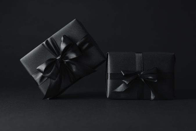 Gift boxes with dark bows on dark background