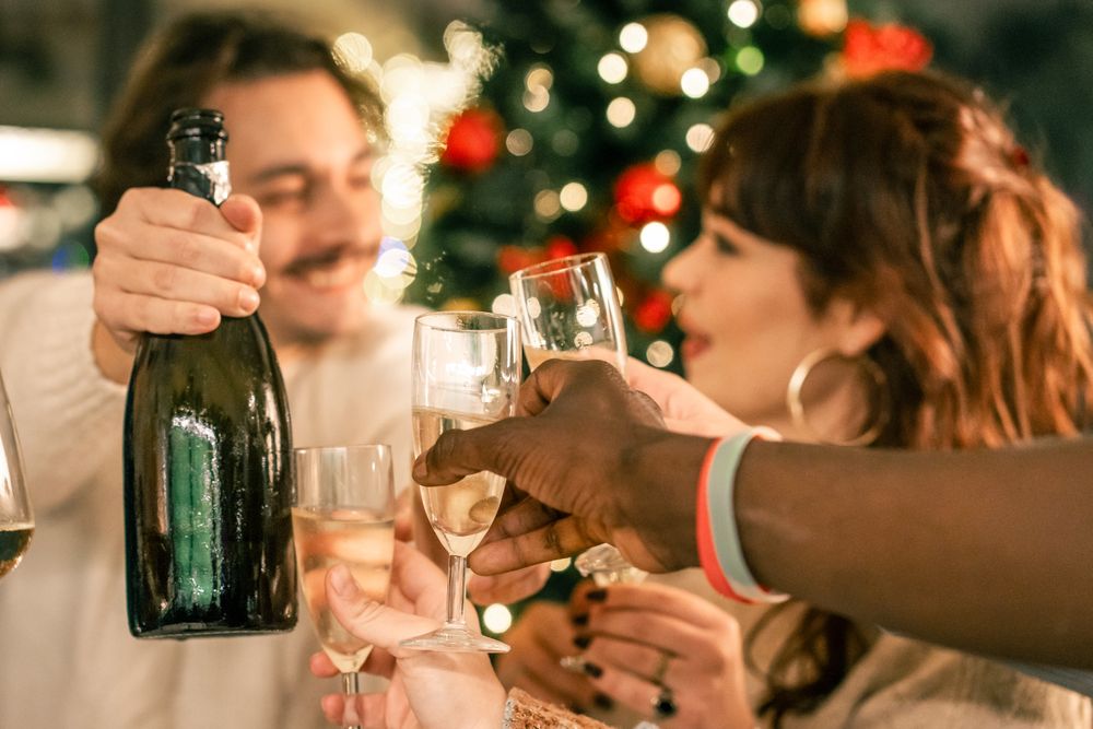 Romantic couple sharing a look while toasting with champagne at a Christmas party.