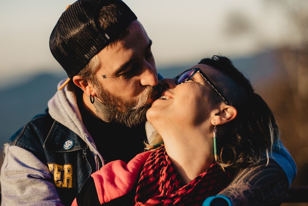 Happy couple hugging near tree in park