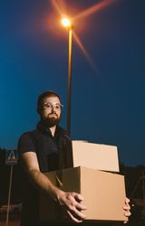 Courier delivering cardboard boxes in evening