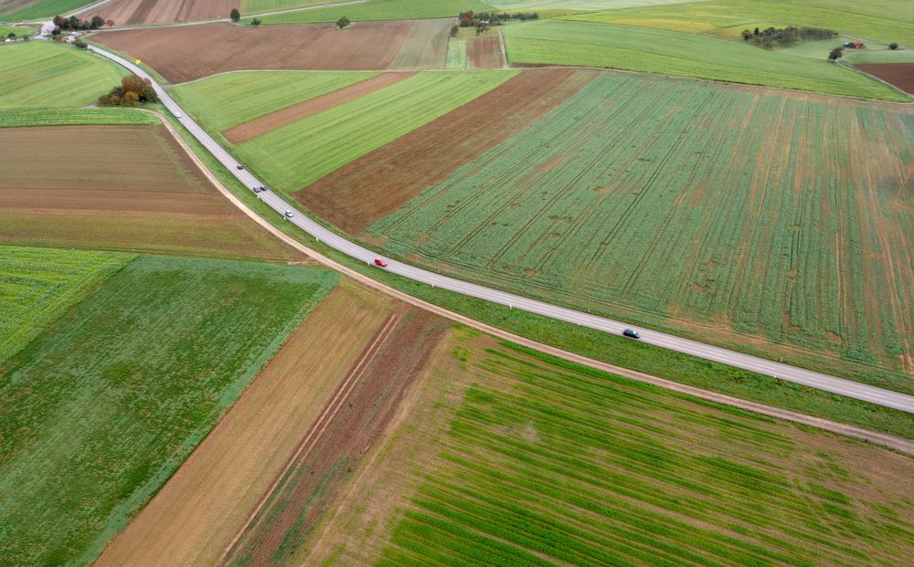 Drone shot of a winding road through agricultural fields in Stuttgart, Germany