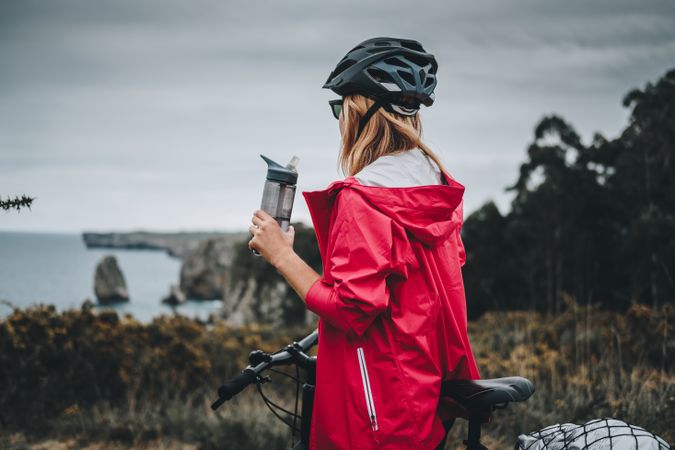 Female bicyclist holding sport bottle