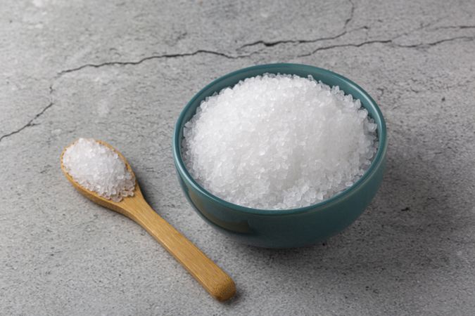 Bowl with coarse salt on the table.