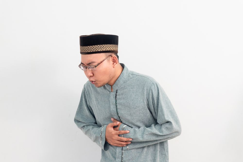 Asian Muslim man feeling touching stomach, hungry during fasting in Ramadan
