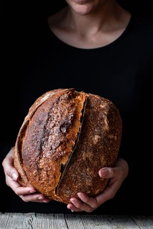 Crop person holding some bread