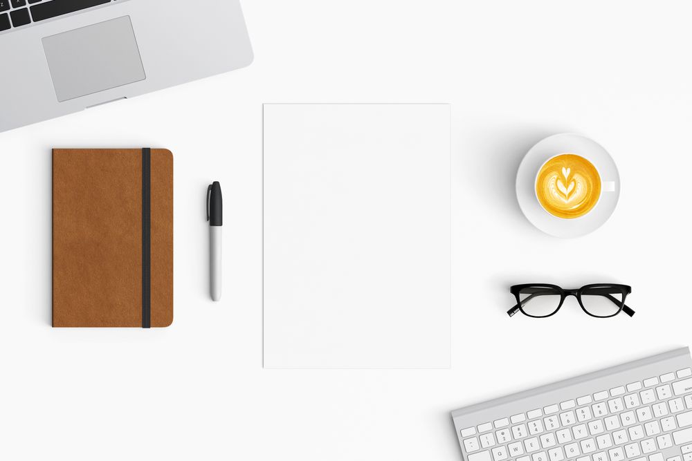Modern workspace with coffee cup, paper, notebook and tablet copy space