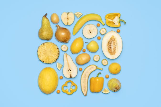 Yellow fruits and vegetables top view on blue background