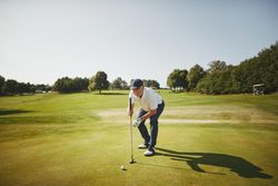 Man preparing to put on golf course