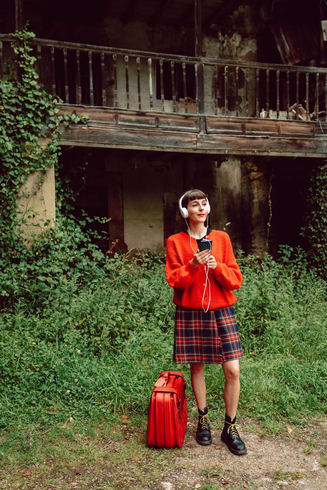 Woman in headphones with suitcase choosing music