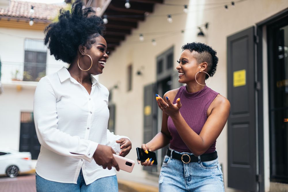 Black women talking and laughing walking in the city
