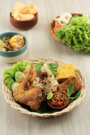 Basket Indonesian chicken dish served with salad and spicy sauce