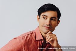 Headshot of curious Hispanic male looking away from camera in grey studio, copy space 0gWqe0
