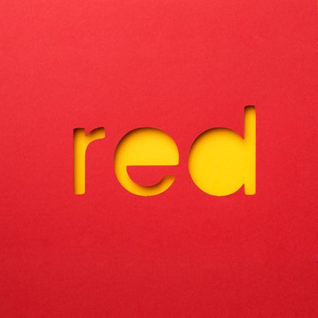 Red word made of paper over yellow background