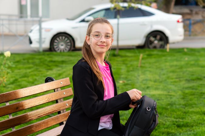 Girl packing her backpack in park.