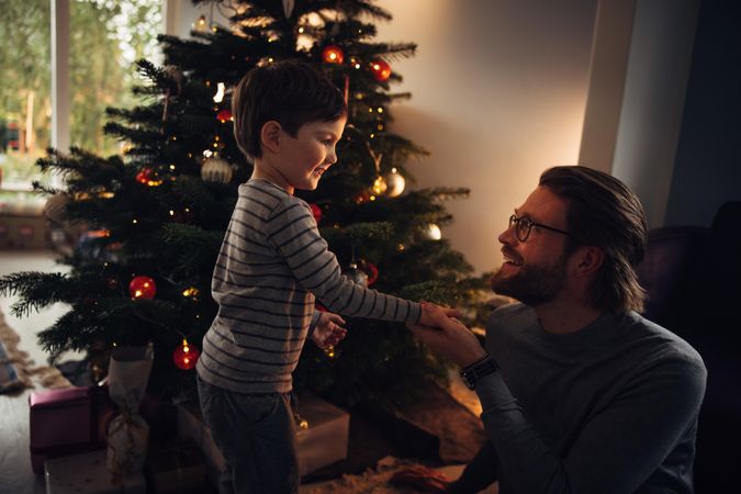 Father and son looking at each other home celebrating Christmas
