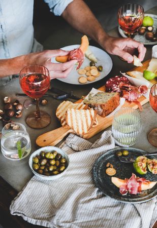 Charcuterie, with wine and snacks and man with prosciutto and melon