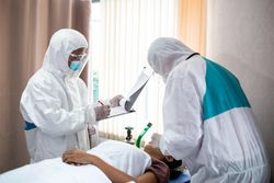 Paramedics in PPE in hospital with patient