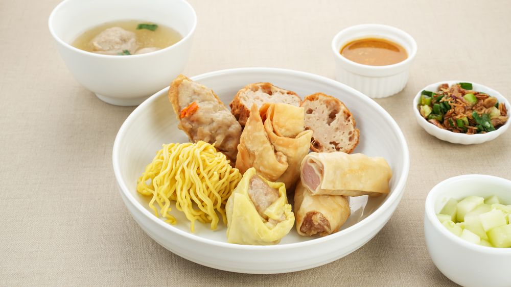 Bakso Malang, meatball soup with tofu, fried shumay, noodles and dumplings. Served with sambal and cucumber