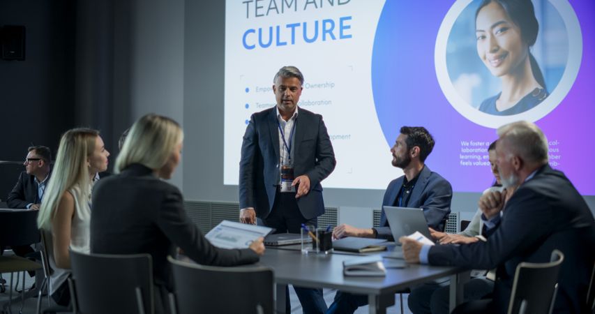 Corporate Event: Male Tech CEO Hosting Team Building Workshop With Diverse Employees In Conference Room Of Innovative Startup Company Office.