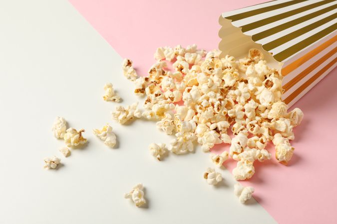 Composition with striped box and popcorn on color background