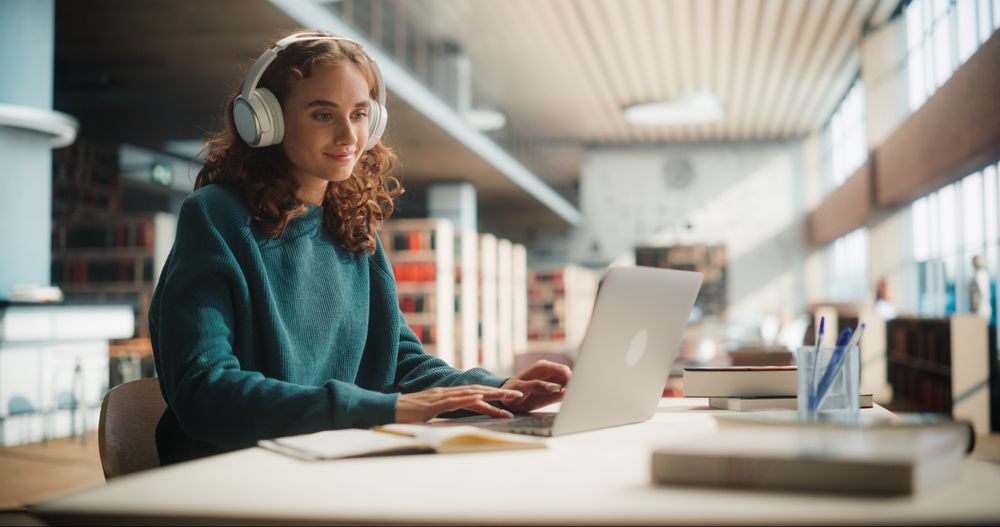 Dedicated Female Student Engaged in Online Learning at a Modern Library.