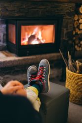 Feet of man resting by the fireplace