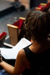 Over the shoulder shot of female director sitting in theater