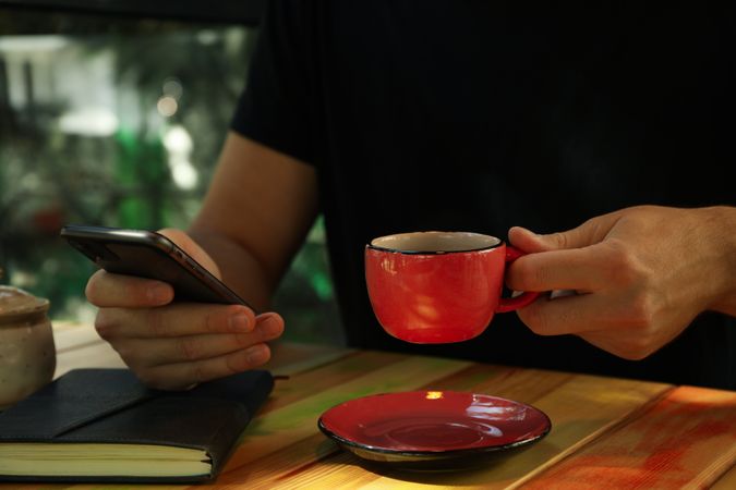 Man using phone and drink coffee in restaurant