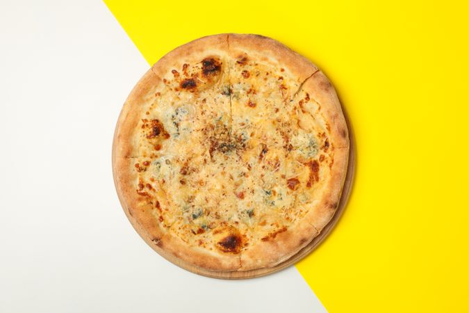 Cheese pizza on two tone background, top view