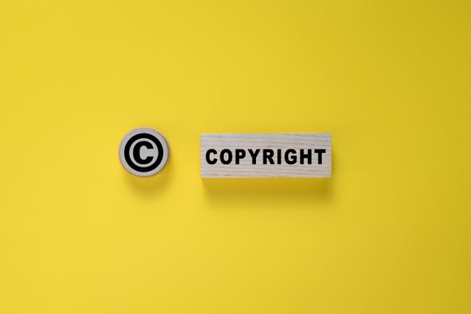 copyright symbol and word on wooden blocks. isolated on yellow background