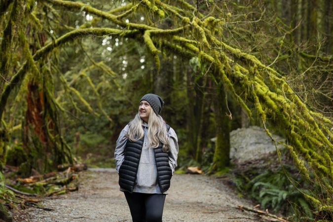 Woman hiking amongst tall trees