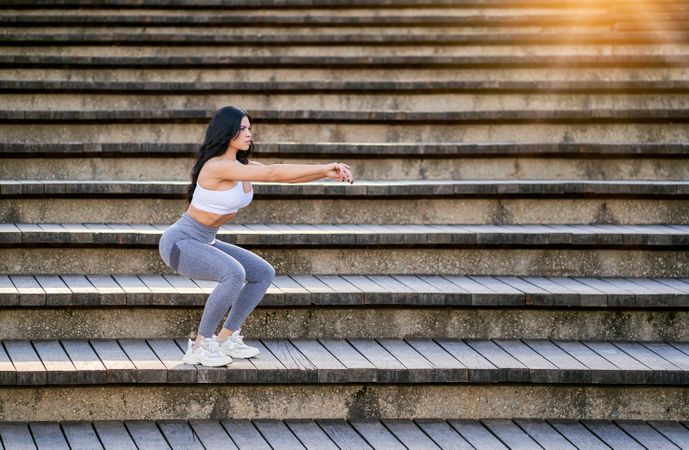 Slim woman doing yoga on stairs