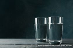 Two glasses of water in dark room on marble table, copy space 4dNoN0
